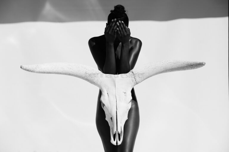 African fine art print featuring human figure and Ankole cattle skull in monochrome by Bernhard Esterer